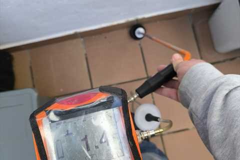 Técnico de OK Fugas de Agua localizando una fuga con detector electrónico y micrófono de suelo en una vivienda